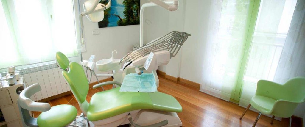 Sala de tratamiento con sillón verde en la clínica France Michaud de Irún